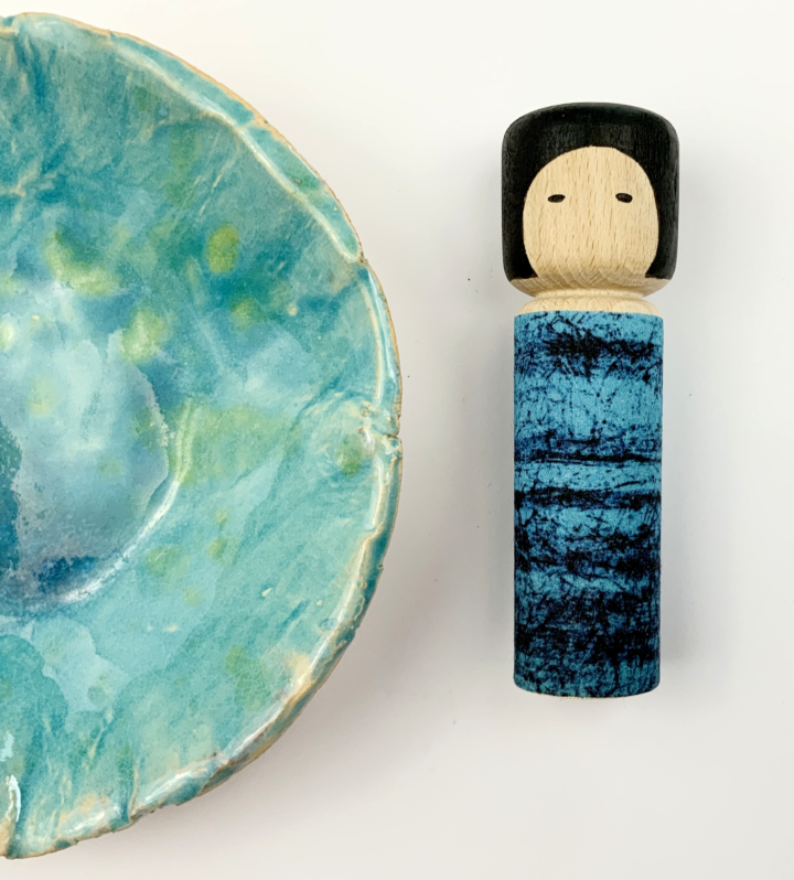 Drewniana laleczka Batikoshi kokeshi w kolorze niebieskim - na imię ma Yume. Laleczka ubrana jest w prinart niebieskiego batiku - materiału wykonanenego w jawajskiej technice malowania tkaniny. Laleczka Batikoshi jest talizmanem, figurką z intencją - Yume jest symbolem marzeń.
