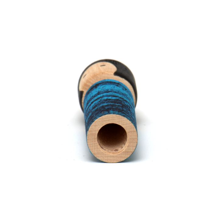 Drewniana laleczka Batikoshi kokeshi w kolorze niebieskim - na imię ma Yume. Laleczka ubrana jest w prinart niebieskiego batiku - materiału wykonanenego w jawajskiej technice malowania tkaniny. Laleczka Batikoshi jest talizmanem, figurką z intencją - Yume jest symbolem marzeń.